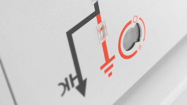 Electrical workers in protective gear working on industrial equipment in a power facility