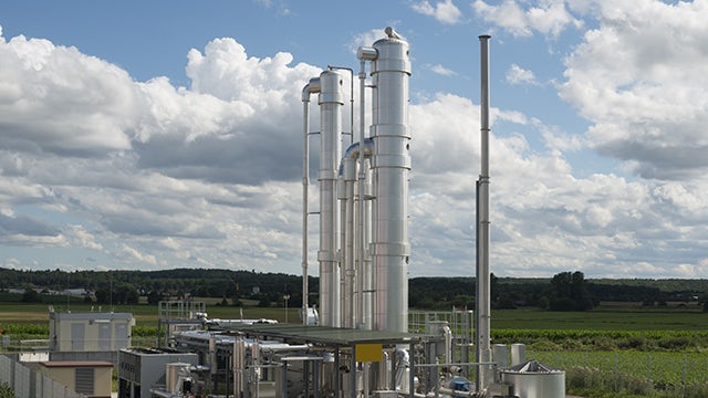 A power station with a large building and a crane in the background.