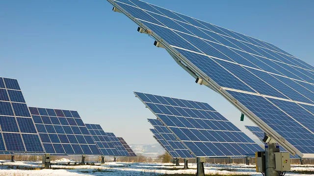 Solar panels installed on a roof with a clear blue sky in the background.
