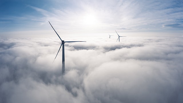 A wind turbine farm with multiple turbines generating electricity in a rural landscape.