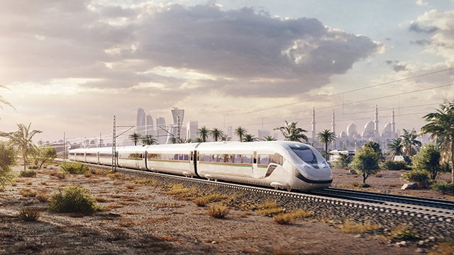 Train on elevated tracks passing through a city with tall buildings in the background