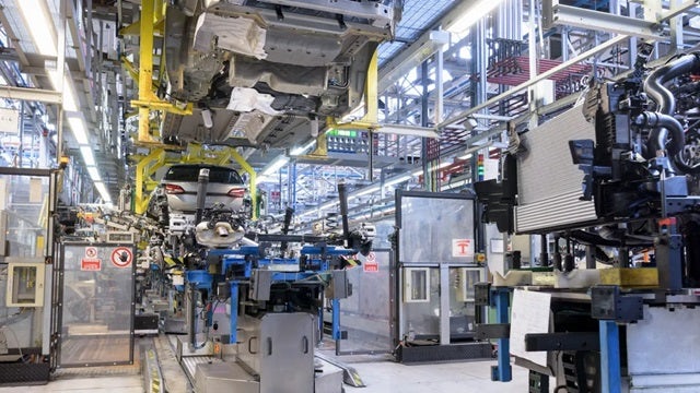 Cars being assembled on an automated assembly line in a smart manufacturing factory