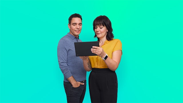 A woman stands in front of a large screen displaying a message about gender equity.