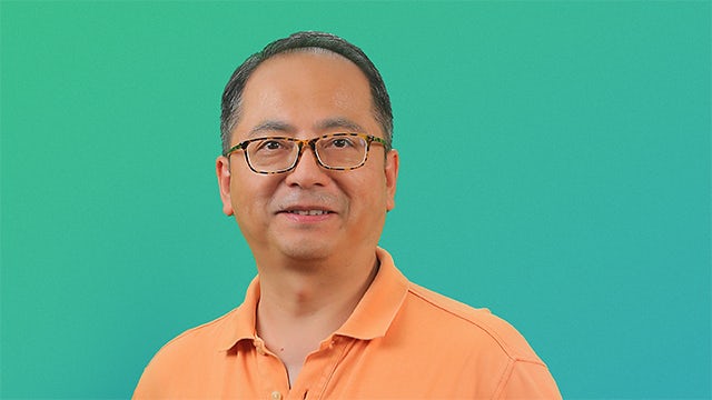 A group of people of different ages and ethnicities standing together, possibly in a meeting or conference.