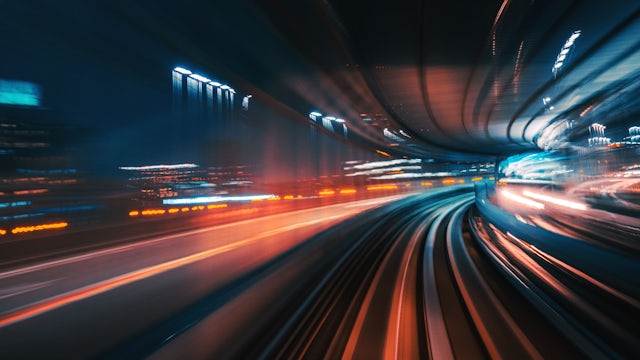 Action shot of cars in a tunnel, showing blurred, curved lines.