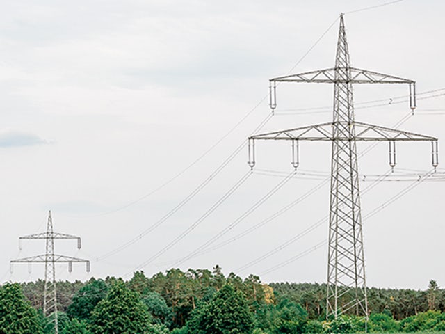 A transmission line with a protective shield and a grid scale logo.
