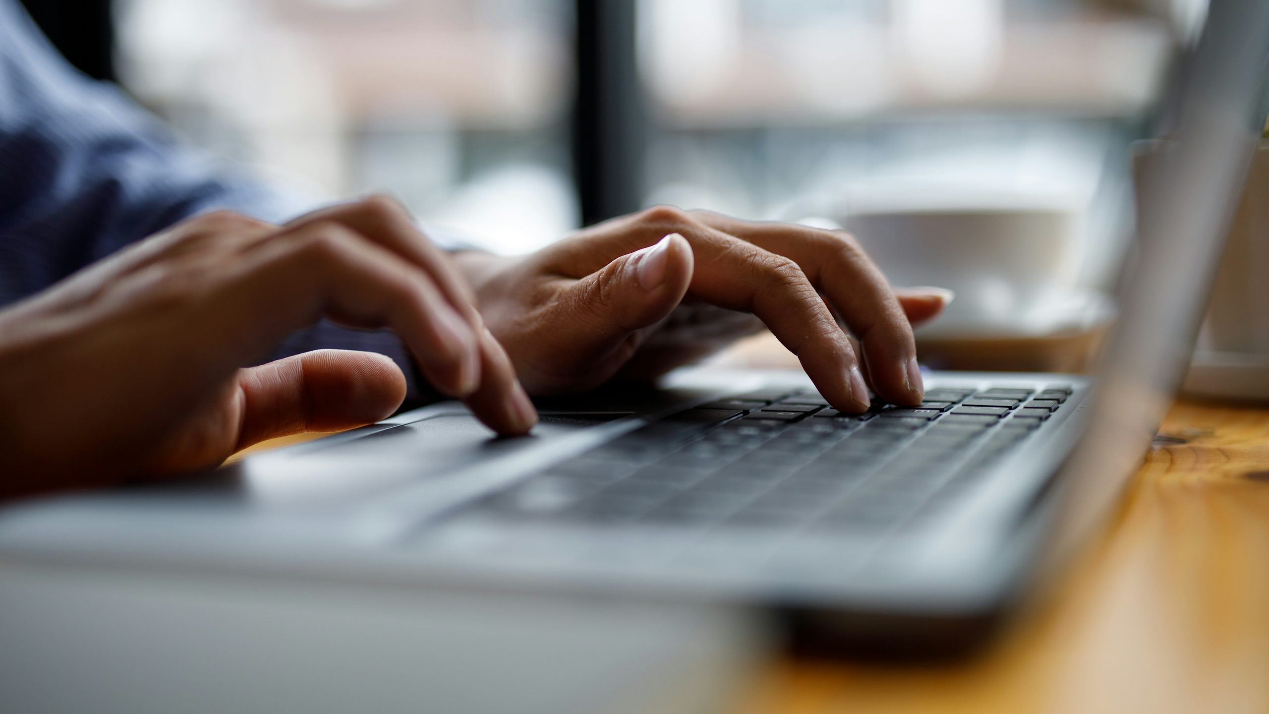 Hands typing on a laptop.