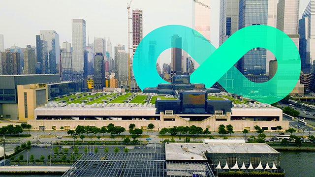 Infinity logo with city skyline during the daytime.