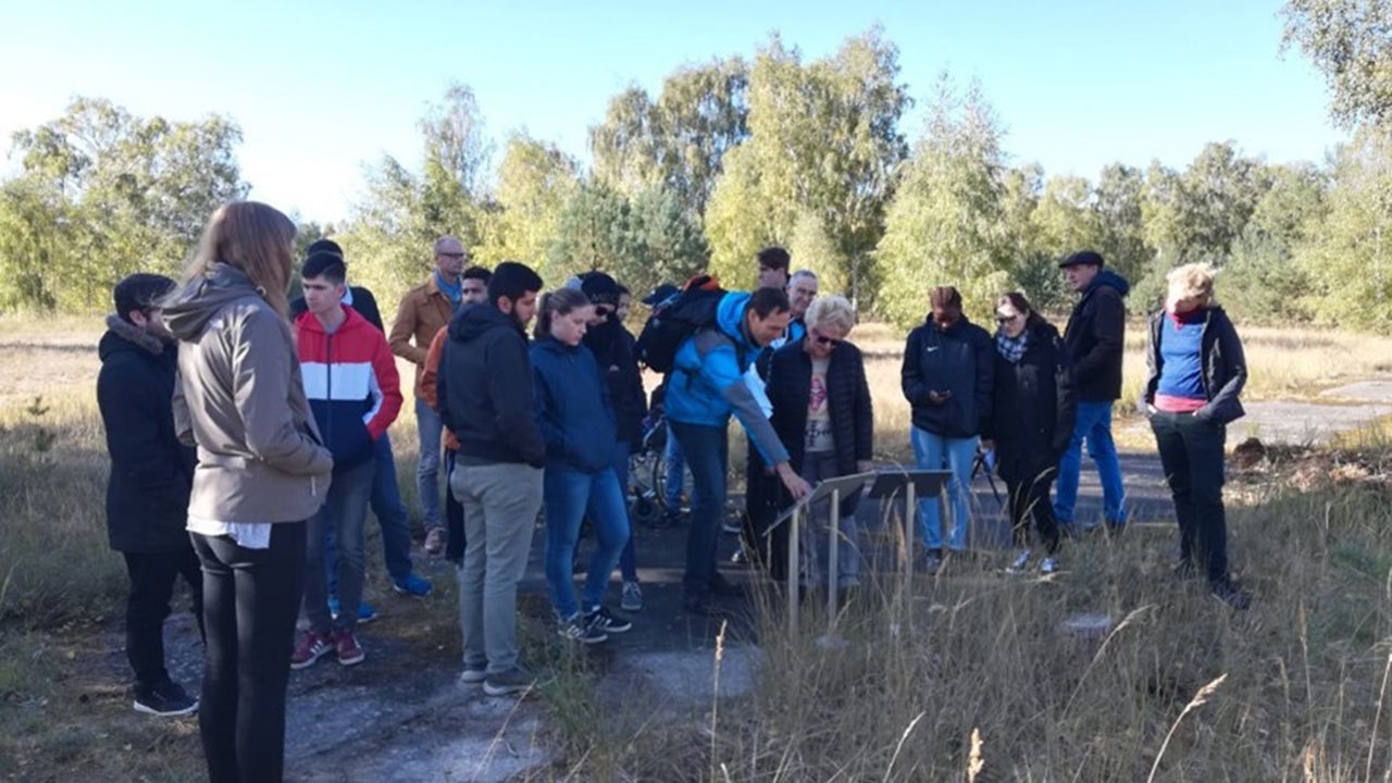 Siemens trainees together with a former forced laborer on the site of the historical Siemens complex in Ravensbrück, 2018.