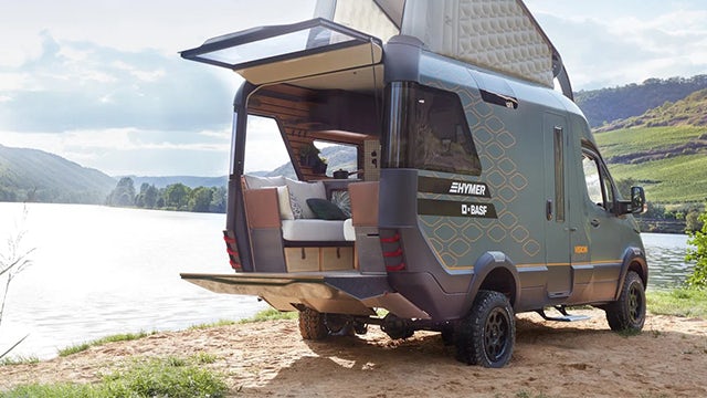 Futuristic white recreational vehicle concept with large windows and sleek design on a gray background