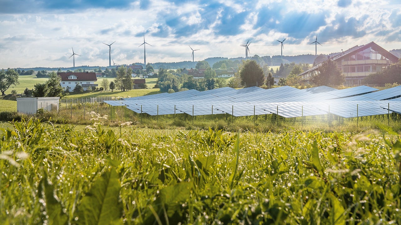 A person is standing in front of a Siemens logo with a blue background.