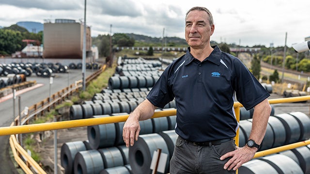 A man stands in an outside environment looking over a production site.