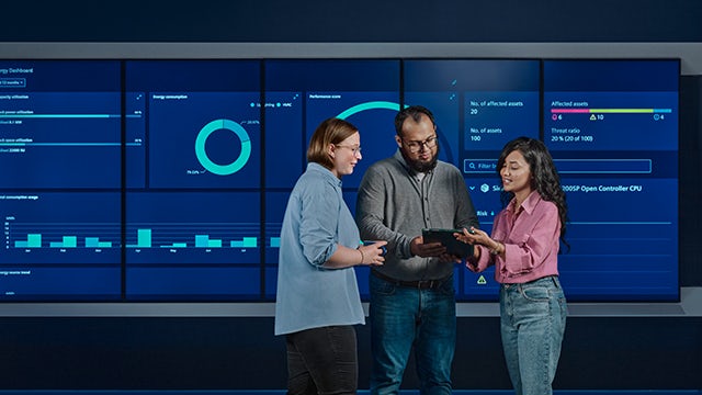 The image shows a group of inventors working together in a lab, with one inventor holding a device and the others looking on.