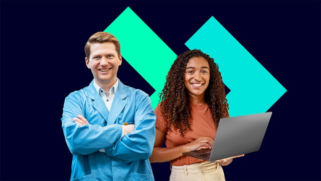 A man wearing a light blue lab coat stands with his arms crossed next to a woman in a brown shirt holding a laptop. 
