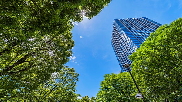A modern building with a sleek design and glass windows reflecting the sky.