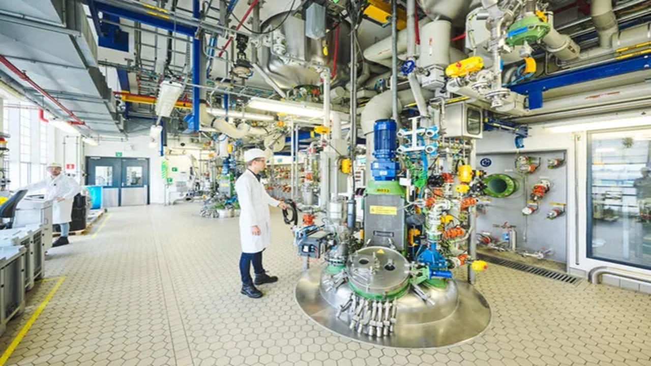 Scientist in lab coat examining test tube in laboratory setting