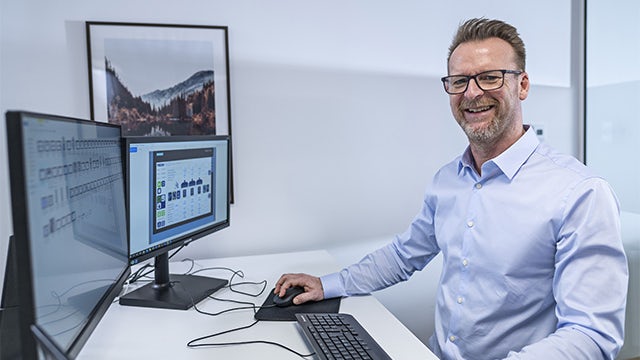 Mark Baumann-Lund, a software engineer, sits at his desk.