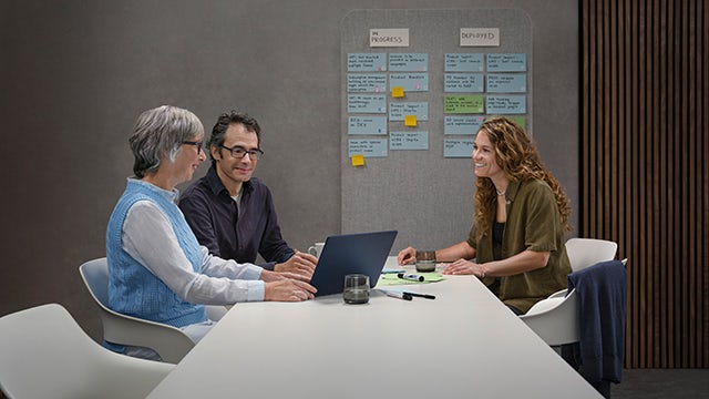 A group of people in a meeting room discussing health and safety leadership.