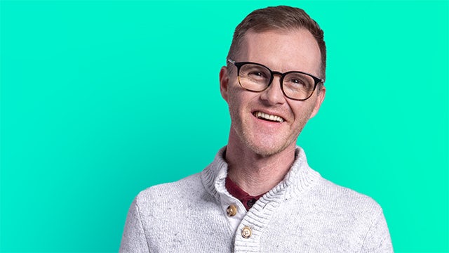 A group of people holding a rainbow flag in a pride parade.