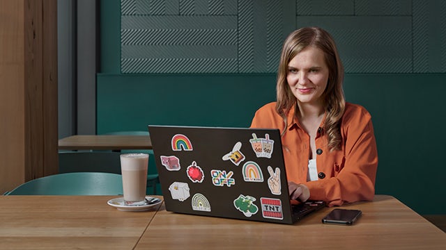A group of people in a meeting room with a projector screen displaying a presentation.