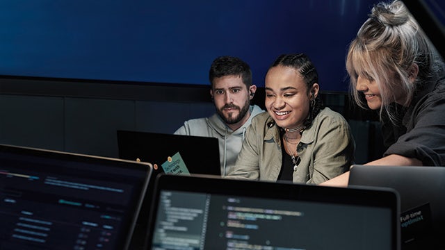 The image shows a group of people working together in an office setting, with a focus on collaboration and teamwork.
