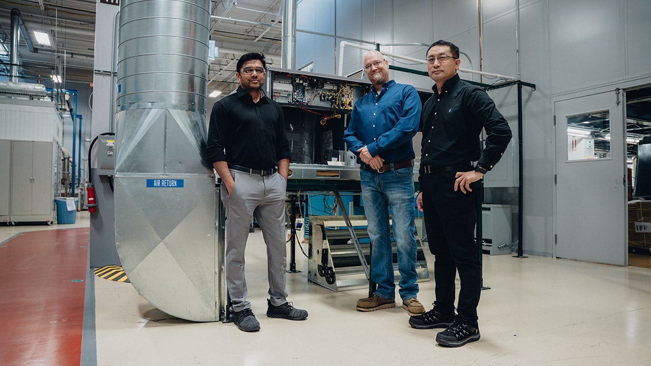 The image shows a person using a smartphone to control an air conditioning system.