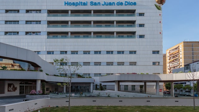 A person is standing in front of a Siemens building in Seville, Spain.