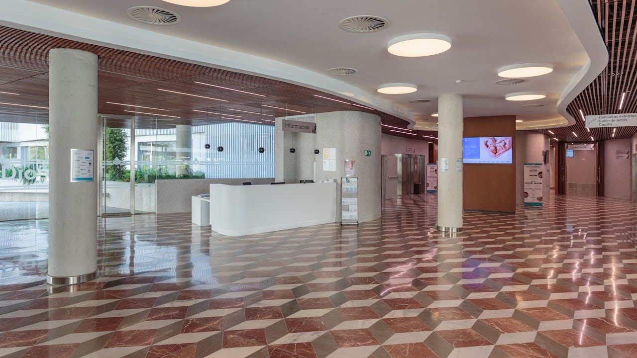 A person is standing in front of a Siemens building in Seville, Spain. 
