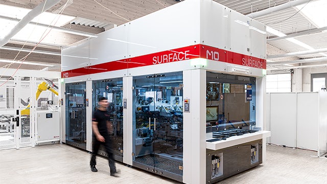 Employee walks past SURFACE, a production plant for shingle matrix solar modules