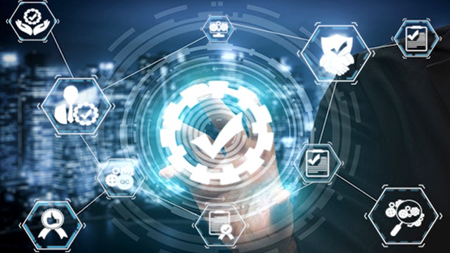 A person is standing in front of a large screen displaying a colorful abstract design.