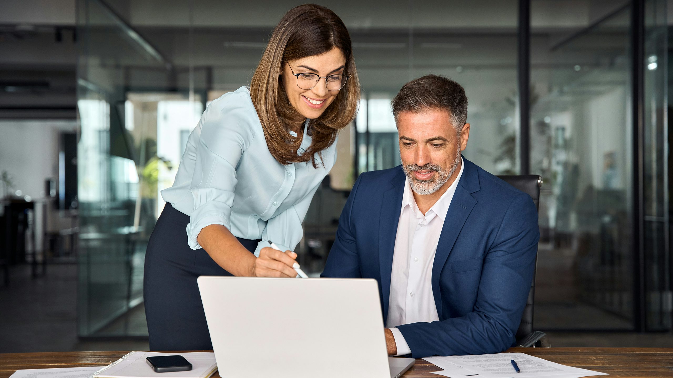 Person using laptop in front of electrical switchgear panels