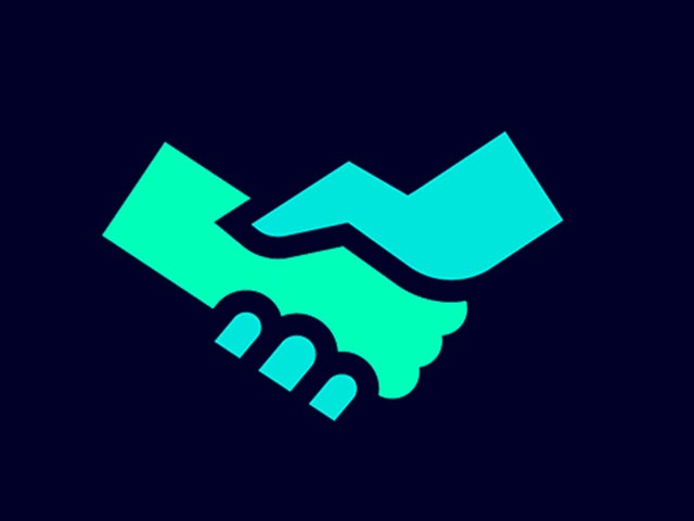 Two people shaking hands in front of electrical panels in an industrial setting