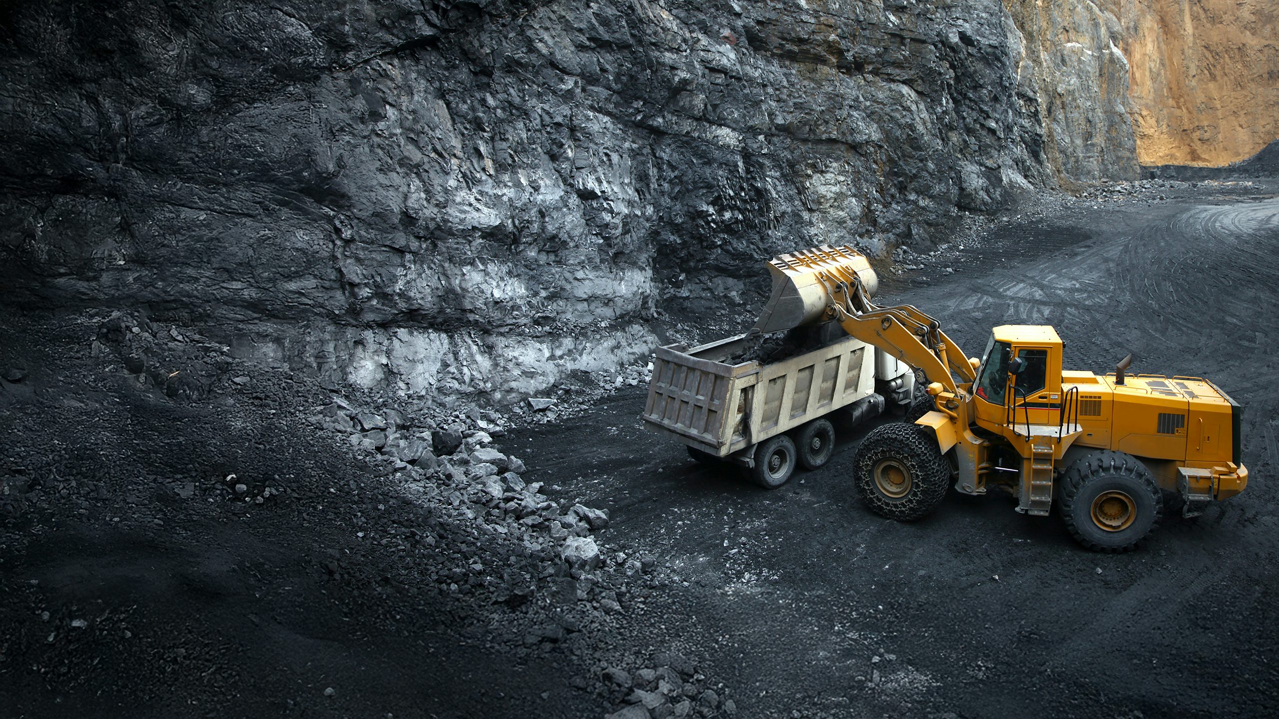 Truck and excavator at a mining site.