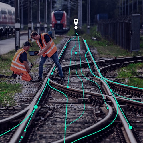 A person is standing in front of a white wall with a blue and white logo on it.