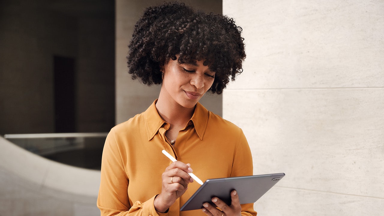 A person wearing a mask and gloves standing in front of a sign that reads 