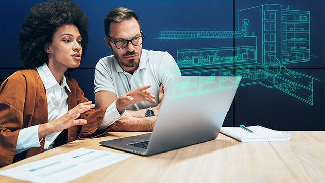 Two people working in front of a laptop.