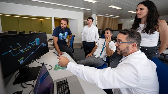 Water experts monitor plant operations onscreen.