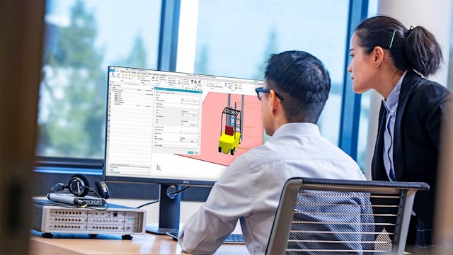 Two engineers using heavy equipment simulation tools. 