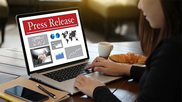 Business people in suits shaking hands in front of office building