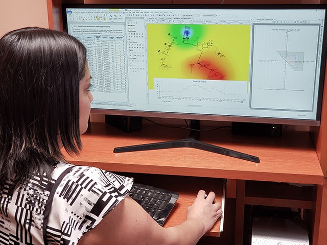 A woman using a program on a monitor.