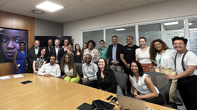 A group of people standing together in front of a building with a Siemens sign.