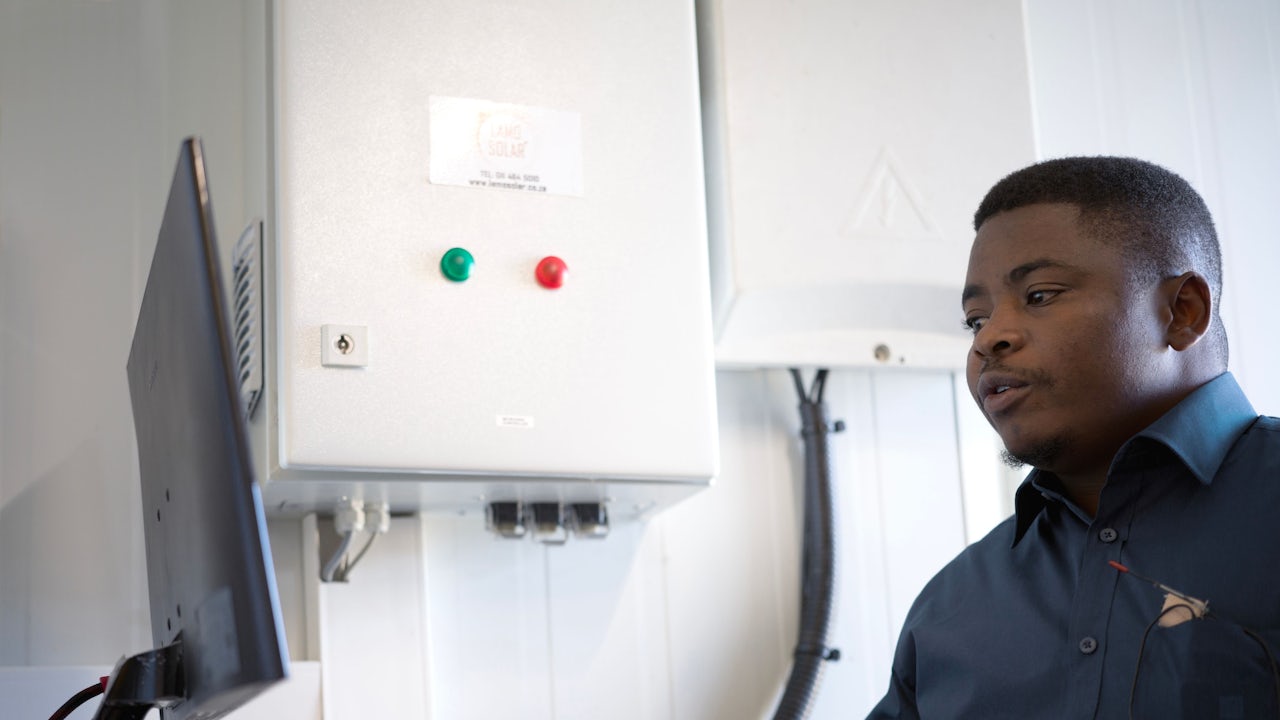 Man typing on computer at power plant.