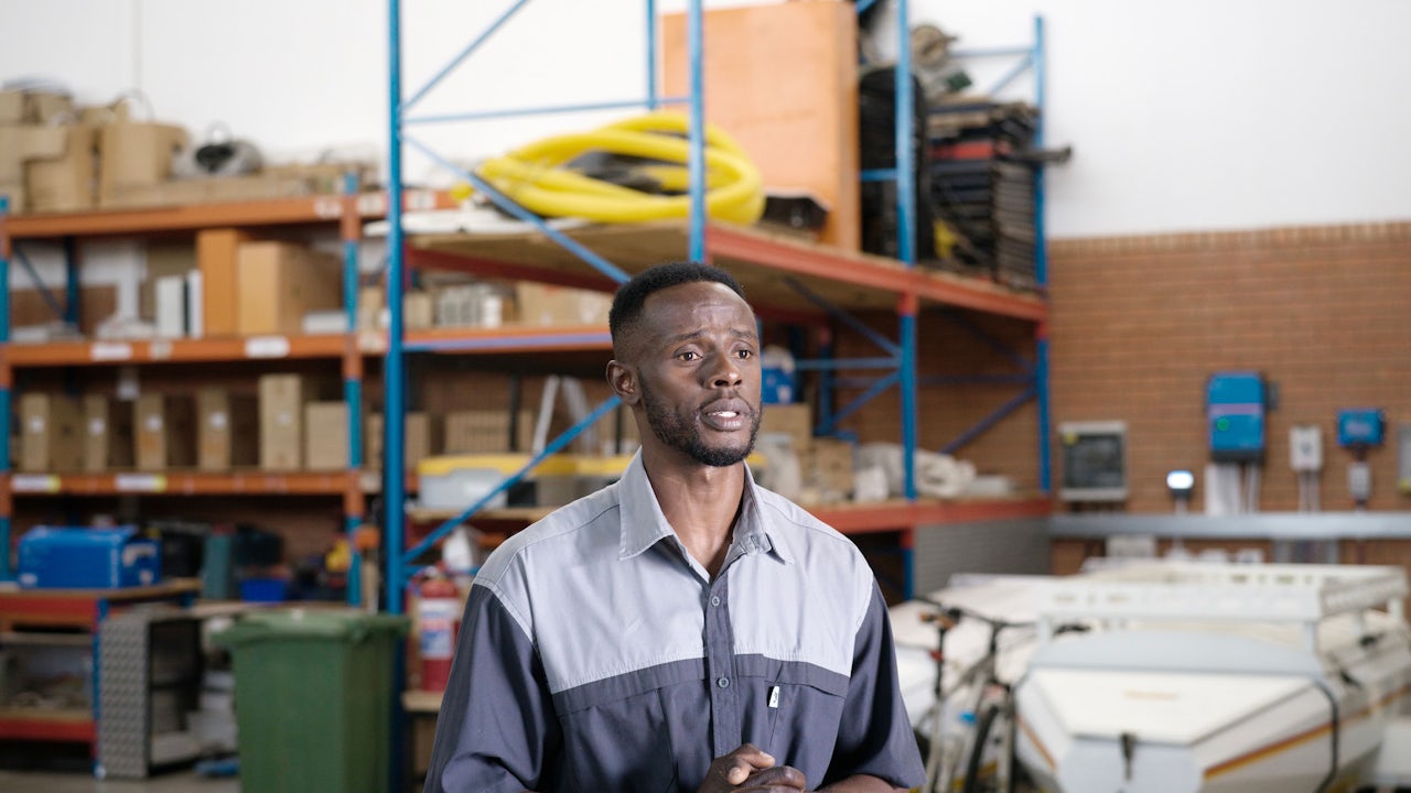 South African man standing in microgrid facility.