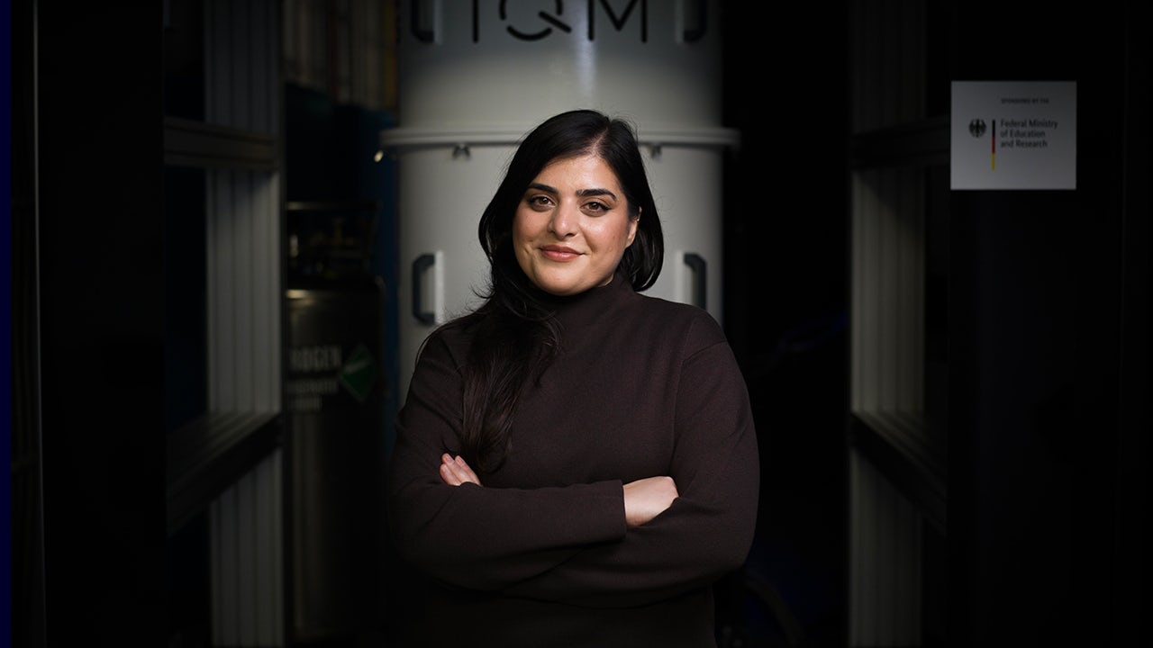 A factory floor with a quantum computer setup and a person working on it.