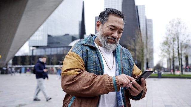 Man using a smartphone in a city setting.