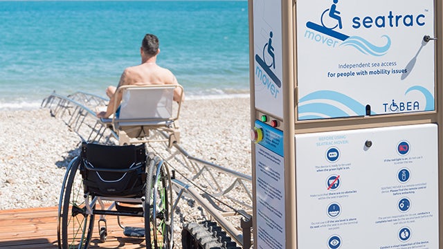 The image shows a ship sailing on the ocean with a clear sky and a distant horizon.