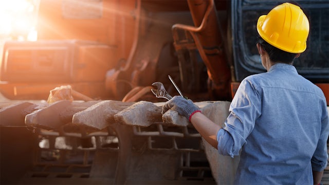 Heavy equipment worker assessing a machine