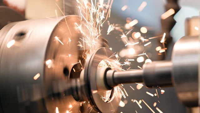 An industrial machine being used to welding and grind a piece of metal.