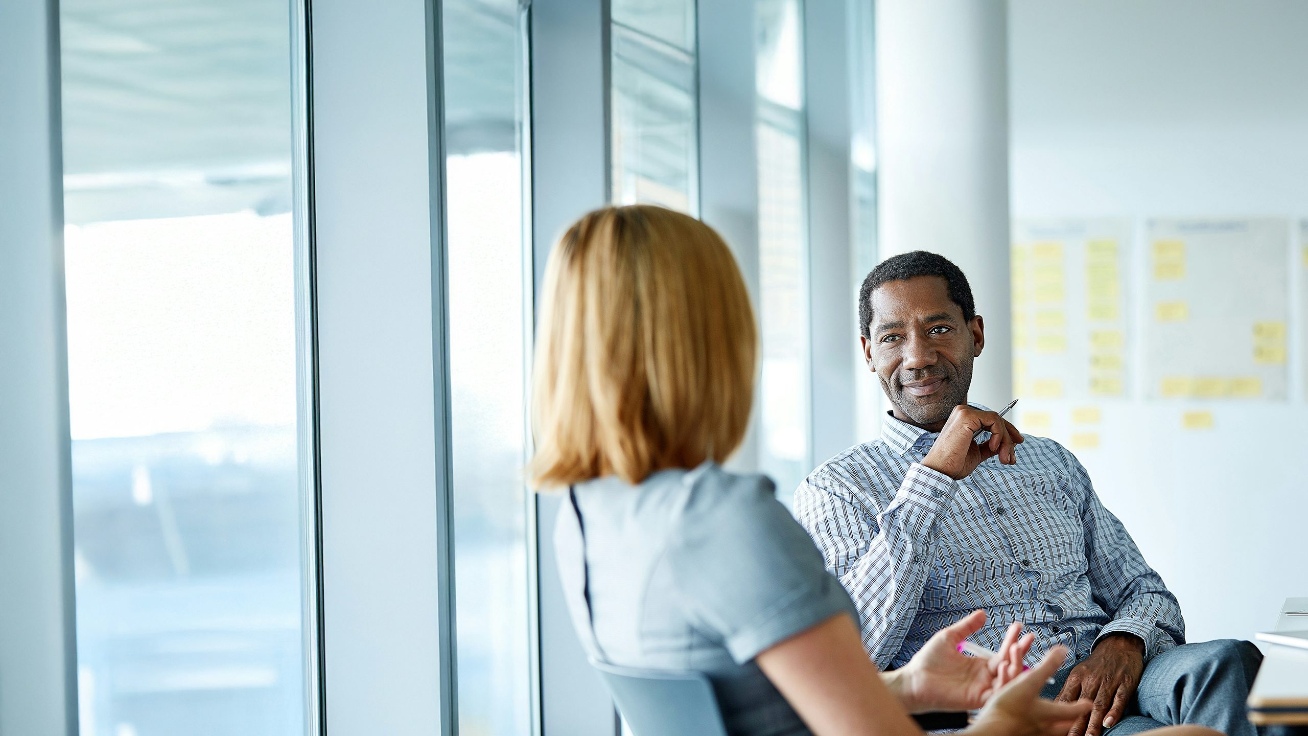 A man and a woman having a pleasant conversation in a conference room.
