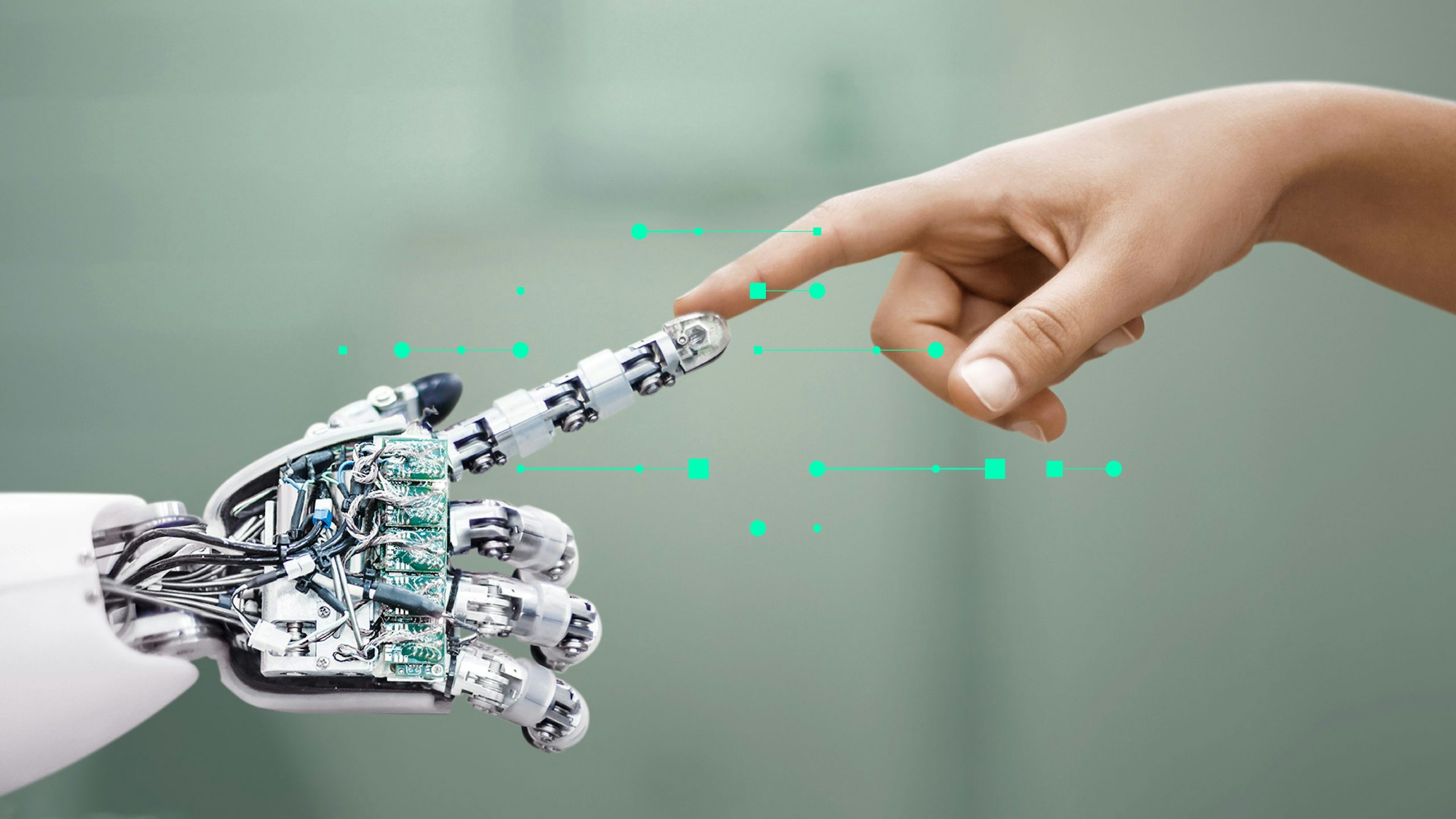 A robot hand reaches out to touch the finger of a human hand. 